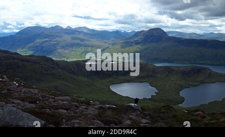 Vista a sud dalle pendici di Bein Ghobhlach, fino a un Teallach e Sail Mhor e le colline dei campi di pescatori. Macchie di sole sulle colline. Include parte Foto Stock