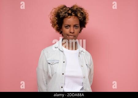 La giovane donna afro-americana è depressa e si preoccupa per la sofferenza. Triste espressione facciale negativa. Foto Stock