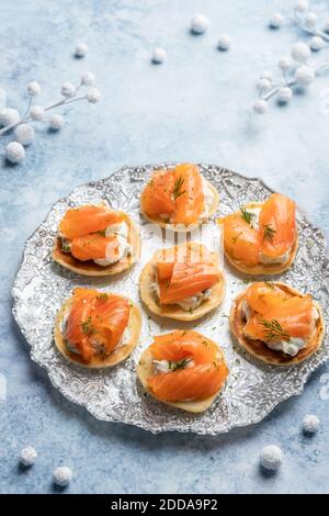 Blini con salmone affumicato e panna acida, guarniti con aneto Foto Stock