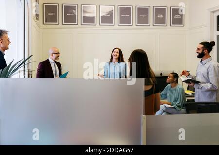 Imprenditori sorridenti che discutono di strategie sul posto di lavoro Foto Stock