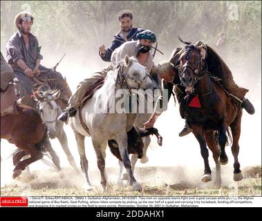 NESSUN FILM, NESSUN VIDEO, NO TV, NESSUN DOCUMENTARIO - © DAVID P. GILKEY/KRT/ABACA. 29683-1. Gulbahar-Afghanistan, 24/10/2001. Due uomini di squadre opposte combattono su una carcassa di capra mentre giocano il gioco nazionale afgano di Buz Kashi, Goat tirando, dove i piloti competono raccogliendo la metà posteriore di una capra e c Foto Stock