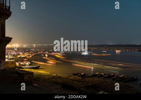 India, Uttar Pradesh, Varanasi, lunga esposizione di barche che navigano lungo il fiume Gange di notte Foto Stock