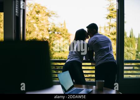 Una coppia che si baciano mentre si è in piedi sul balcone Foto Stock