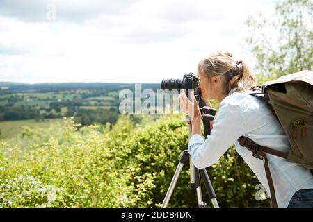 Donna anziana attiva scattando foto con la fotocamera della natura giorno di sole Foto Stock