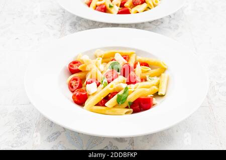 Piatto di pasta vegetariana con mozzarella, pomodori ciliegini e basilico Foto Stock