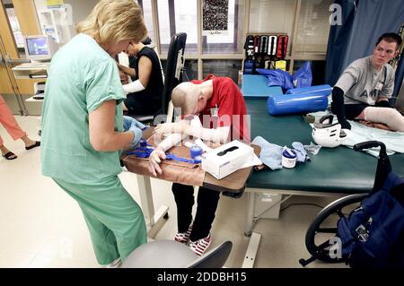 NO FILM, NO VIDEO, NO TV, NO DOCUMENTARIO - Marine Lance Corporal Aaron Mankin (C) incuola la testa come assistente certificato di terapia professionale Stephanie Angle ribende la sua mano sinistra al Brooke Army Medical Center a San Antonio, Texas, USA, il 20 luglio 2005. Mankin si sta riprendendo dalle ferite che ha ricevuto l'11 maggio, quando il portaerei che stava cavalcando vicino al confine siriano con l'Iraq ha corso su una miniera anticarro. Foto di Ralph Lauer/Fort Worth Star Telegram/KRT/ABACAPRESS.COM. Foto Stock