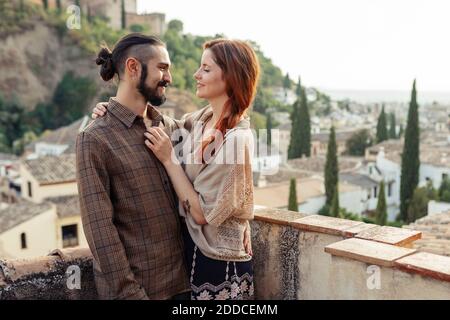 Uomo e donna si abbracciano mentre si levano in piedi sul tetto Foto Stock