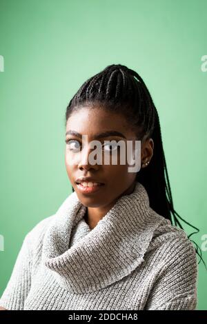 Giovane donna su sfondo verde in studio Foto Stock