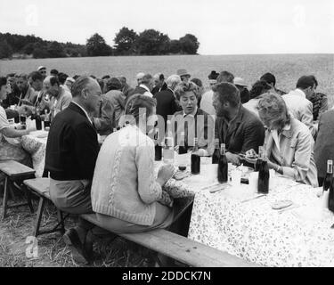 KIRK DOUGLAS in costume come Vincent Van Gogh sul set Luogo cantato in Auvers-sur-Oise in Francia pranzo con il suo Moglie ANNE BUYDENS DOUGLAS e produttore JOHN HOUSEMAN e suo Moglie JOAN HOUSEMAN con cast e l'equipaggio durante le riprese di LUSSURIA PER LA VITA 1956 regista VINCENT MINNELLI romanzo Irving Stone Sceneggiatura Norman Corwin music Miklos Rozsa produttore John Houseman Metro Goldwyn Mayer Foto Stock