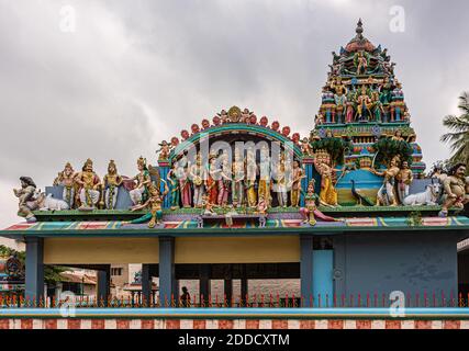 Kadirampura, Karnataka, India - 4 novembre 2013: Tempio di Sri Murugan. Statue colorate sul tetto di Mandapam e sulla torre di Vimanam sotto il paesaggio nuvoloso grigio. Foto Stock