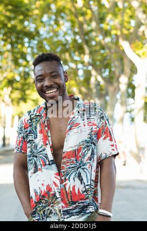 Giovane allegro in casuals in piedi sulla strada Foto Stock