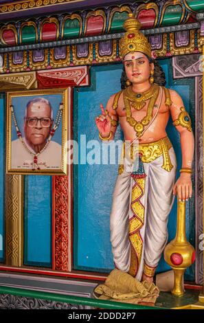 Kadirampura, Karnataka, India - 4 novembre 2013: Tempio di Sri Murugan. Primo piano della statua della guardia di Dwarapalaka con club e foto di benefattore contro bl Foto Stock