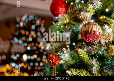 Primo piano di oro rosso boble sull'albero di natale. chirstmas con luci che si riflettono nella finestra a casa. Concetto di natale. Albero soggiorno. Foto Stock