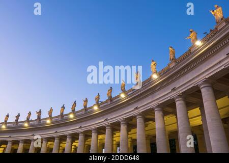 Statue di santi illuminate sulla Basilica di San Pietro contro il cielo blu chiaro al tramonto, Città del Vaticano, Roma, Italia Foto Stock