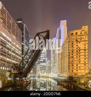 Ponte sul fiume da edifici in città di notte, Chicago, Stati Uniti Foto Stock