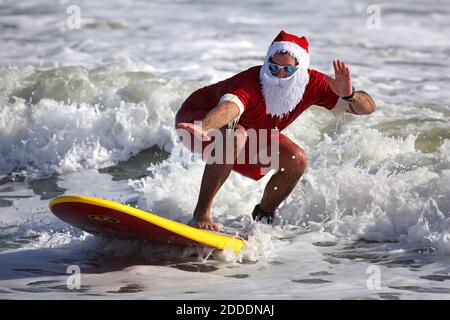 NO FILM, NO VIDEO, NO TV, NO DOCUMENTARIO - Surfers don Santa outfits durante il Surfing Santas di Cocoa Beach fundraiser a Cocoa Beach, FL, USA, mercoledì 24 dicembre 2014. Centinaia vestiti in costume e coraggiosi il fresco surf per l'evento, ora al suo sesto anno. I proventi sostengono il Cocoa Beach Surf Museum e Grind for Life, una associazione benefica locale che assiste i malati di cancro. Foto di Joe Burbank/Orlando Sentinel/TNS/ABACAPRESS.COM Foto Stock