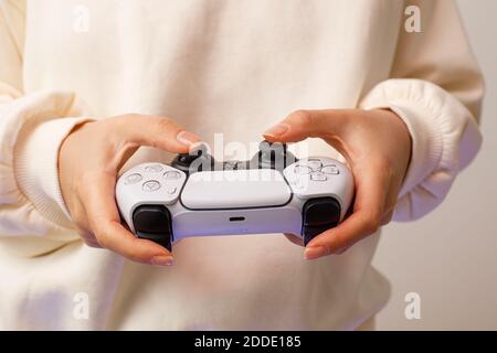 PlayStation 5 Sony svela console e giochi per PS5. Controller Dualsense. Donna che tiene il joystick Foto Stock