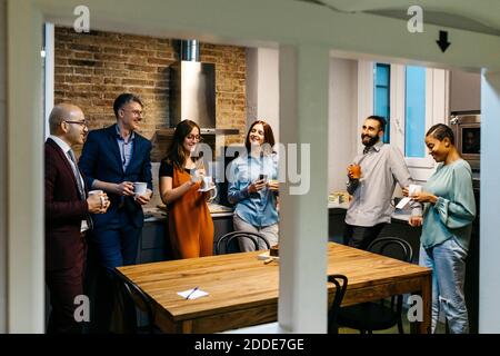 Imprenditori maschili e femminili che discutono mentre hanno il caffè in ufficio cucina Foto Stock
