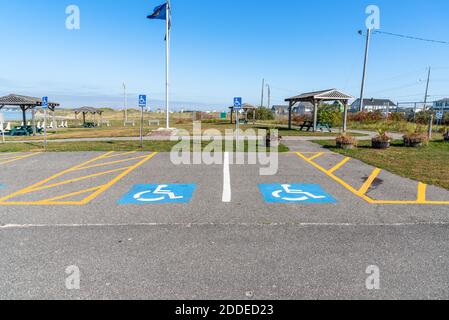 Spazi di parcheggio vuoti per disabili in un parco pubblico su una giornata autunnale limpida Foto Stock