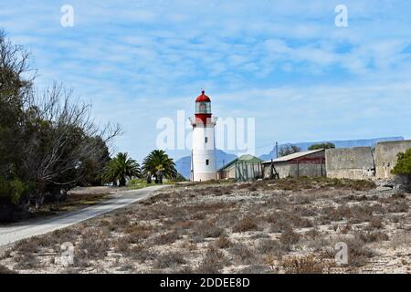 Il faro sull'isola di Robben, Caoe Town, Sudafrica. Table Mountain si può vedere dietro il faro attraverso Table Bay. Foto Stock