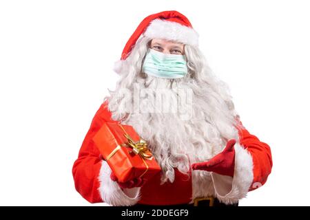 Babbo Natale con maschera viso offre un regalo di natale, isolato su sfondo bianco. Foto Stock