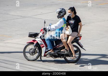 SAMUT PRAKAN, THAILANDIA, 27 2020 LUGLIO, UN tassista su una moto giri con una donna. Il conducente del mototaxi trasporta un passeggero. Foto Stock