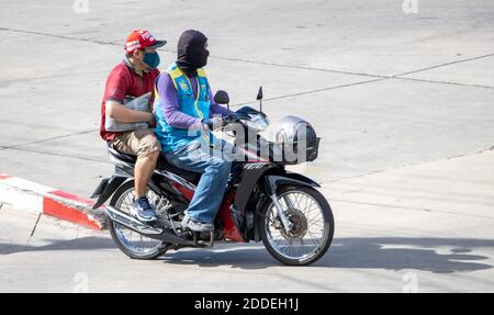 SAMUT PRAKAN, THAILANDIA, 27 2020 LUGLIO, UN tassista su una moto giri con un uomo con maschera. Foto Stock