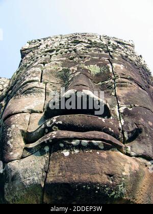 Grande pietra dettagliata scolpito faccia a Bayon, Cambogia, fa parte del complesso Angkor Thom che comprende oltre 200 delle enormi facce serene. Noti per l'architettura barocca Khmer, i volti sono diventati un simbolo dell'orgoglio cambogiano nel suo patrimonio culturale. Foto Stock