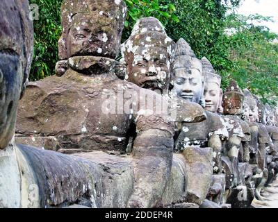 Devas, o demigodi, sono icone che si trovano all'interno del complesso Angkor Thom vicino Siem Reap, Cambogia. Angkor Thom e la vicina Angkor Wat coprono più di 400 acri ed è considerato il più grande monumento religioso del mondo. In primo luogo un complesso di tempio indù, si è spostato ad un buddista con la città che termina la relativa funzionalità in 1431. Il complesso templare è stato riscoperto negli anni '90 ed è stato un sito archeologico, e la principale attrazione turistica, da allora. Il Devas di pietra protegge la strada rialzata che conduce ad Angkor Thom. Foto Stock