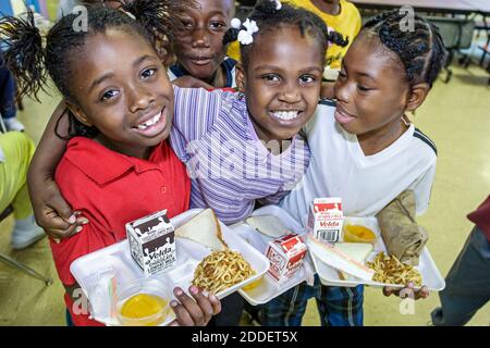 Miami Florida,Little Haiti Edison Park Elementary School,studenti ragazze nere amici caffetteria pranzo vassoio, Foto Stock