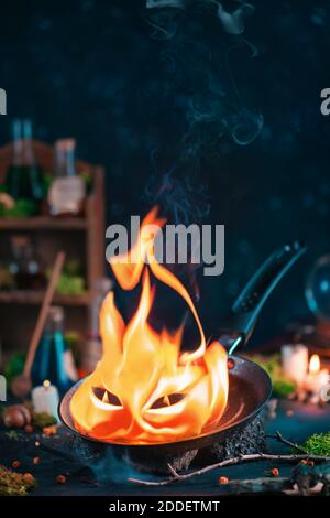 Spirito di fuoco grumpy su una padella, incantesimo di summon, vita magica still con spazio di copia Foto Stock