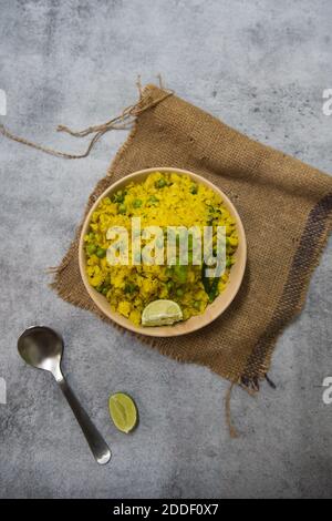 Cibo indiano POHA o riso appiattito in una ciotola su uno sfondo. Foto Stock