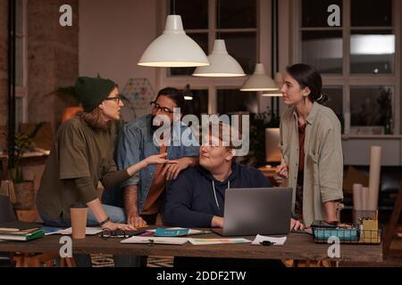 Uomini d'affari in abbigliamento casual discutere insieme presentazione on-line laptop che lavora in squadra Foto Stock