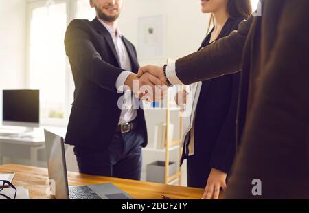 I partner commerciali scuotono le mani dopo un incontro di negoziazione riuscito in moderno ufficio Foto Stock