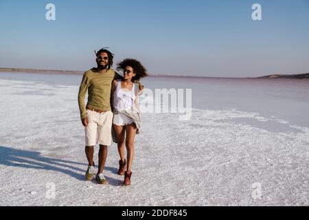 Giovane coppia africana che ama camminare lungo la riva del mare Foto Stock