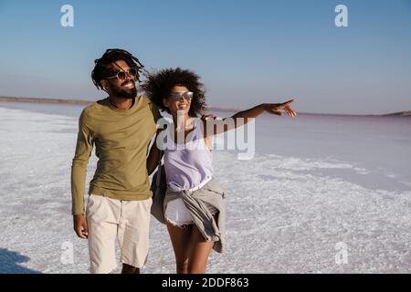 Giovane coppia africana che ama camminare lungo la riva del mare Foto Stock