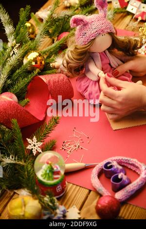 Creare bambola regalo di Natale per i bambini. Vista in primo piano di una bambola realizzata a mano con messa a fuoco selettiva degli accessori Foto Stock