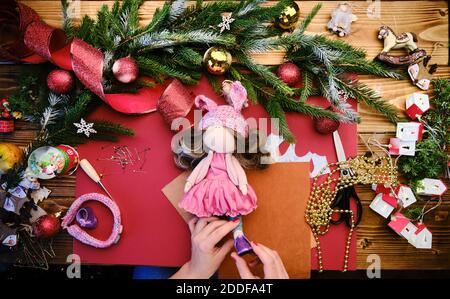 Creare bambola regalo di Natale per i bambini. Vista in primo piano di una bambola realizzata a mano con messa a fuoco selettiva degli accessori Foto Stock