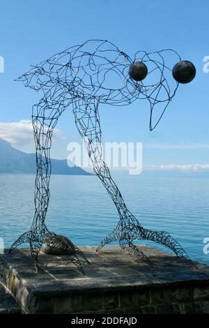 Filo linea arte enorme uccello figurine con grandi occhi sopra l'acqua attraverso le alte montagne. Grande uccello che guarda in profondità nella fotocamera. Cieli aperti con poche nuvole Foto Stock