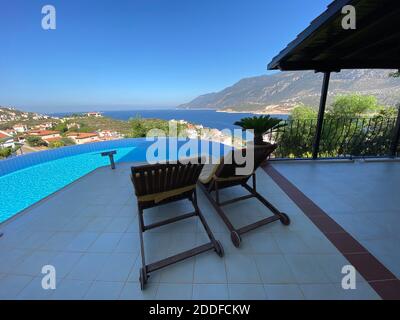 Villa estiva con splendida piscina a sfioro e splendida vista panoramica sul mare in un giardino privato isolato. Un'idea di vacanza romantica per coppie solarium. Foto Stock