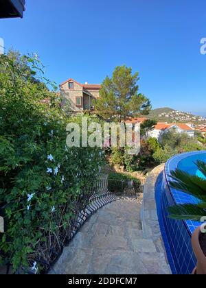 Villa estiva con splendida piscina a sfioro e splendida vista panoramica sul mare in un giardino privato isolato. Un'idea di vacanza romantica per coppie solarium. Foto Stock