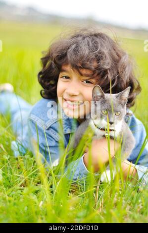 Ragazza molto carina con gatto sul prato Foto Stock