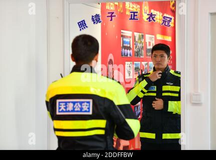 (201125) -- TIANJIN, 25 novembre 2020 (Xinhua) -- Zhao Canwen si addice ad una stazione di polizia nel comune di Tianjin della Cina settentrionale, 23 novembre 2020. Zhao Canwen, 29 anni, è vice capo delle guardie motociclistiche sotto il Tianjin Municipal Traffic Management Bureau. Un amico umoroso per la maggior parte dei suoi colleghi, Zhao diventa serio in nessun tempo una volta che appare al campo di allenamento. Prima di trasformarsi in un poliziotto sette anni fa, Zhao ha lavorato per un'azienda straniera investita dopo la laurea con una laurea in ingegneria del software. È capitato di leggere un messaggio di reclutamento dell'autorità di polizia locale Foto Stock