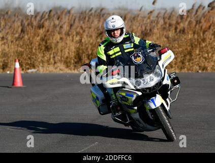 (201125) -- TIANJIN, 25 novembre 2020 (Xinhua) -- Zhao Canwen si allena con un motociclo di polizia in un campo di addestramento nel comune di Tianjin, nel nord della Cina, 23 novembre 2020. Zhao Canwen, 29 anni, è vice capo delle guardie motociclistiche sotto il Tianjin Municipal Traffic Management Bureau. Un amico umoroso per la maggior parte dei suoi colleghi, Zhao diventa serio in nessun tempo una volta che appare al campo di allenamento. Prima di trasformarsi in un poliziotto sette anni fa, Zhao ha lavorato per un'azienda straniera investita dopo la laurea con una laurea in ingegneria del software. È capitato di leggere un messaggio di reclutamento dal locale Foto Stock