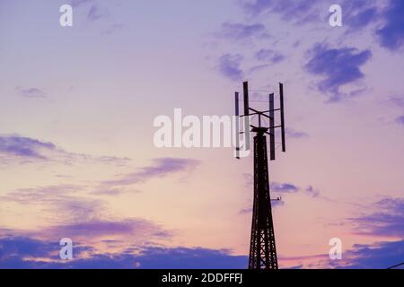 Torre delle telecomunicazioni contro il cielo del tramonto in serata Foto Stock