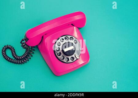 Telefono in plastica vintage su sfondo ciano. Foto Stock
