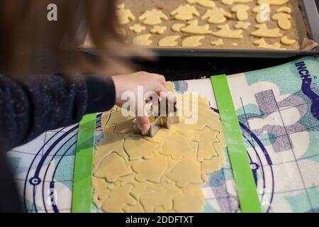 Bamberg, Germania 22 novembre 2020: Symbolbilder - 2020 - dalla pasta fatta in casa, che viene arrotolata su un tappetino, un bambino taglia i biscotti in forme diverse. Sullo sfondo si può vedere una teglia con carta pergamena su cui sono tagliati i biscotti. | utilizzo in tutto il mondo Foto Stock