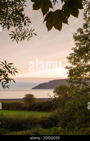 La luce del mattino su Porlock Bay e Bossington Hill vista da Worthy nel Parco Nazionale di Exmoor, Somerset, Inghilterra. Foto Stock