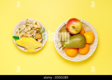 Assortimento di frutta secca e cruda su sfondo giallo, concetto di cibo sano Foto Stock