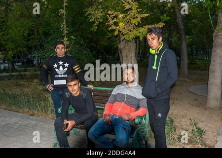 Un gruppo di giovani iraniani seduti in panchina nel parco di Teheran, Iran Foto Stock